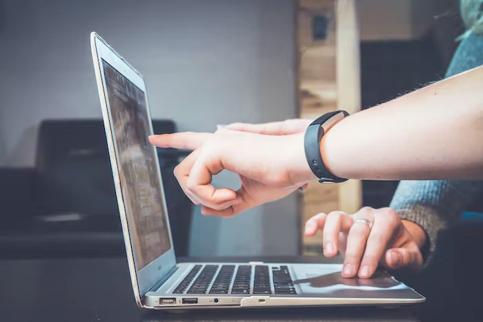 Person pointing a laptop screen